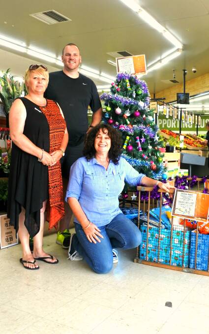 The Christmas spirit: Wendy Worthy and Karyn Callaughan from Circle of Friends with IGA owner Steve Smith at the Christmas giving tree. Photo: Jessica Cole. 