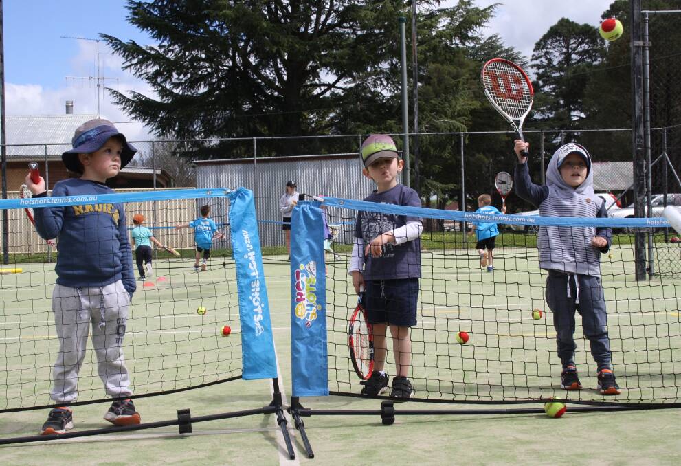 RALLY: Budding young tennis players Xavier Doyle, Henry Nicholls and Fletcher Douglas have some fun while learning from the best at the Hume Tennis Club courts on Monday.