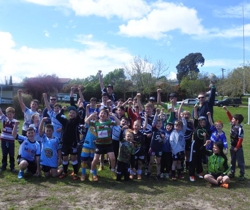 Holiday fun: NRL development officers Adam Kyle, Aaron Peat and Luke Branighan introduces rugby league to juniors from the Yass Valley Region. Photo: Toby Vue
