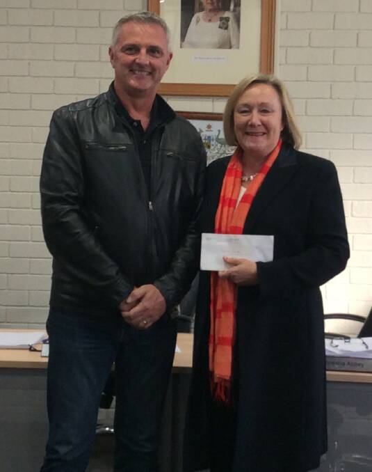 HELPING HAND: Bruce Gunter, organiser of Haulin' the Hume, presents the $5000 donation to Yass Valley Mayor Rowena Abbey. Photo: Gill Elphinston