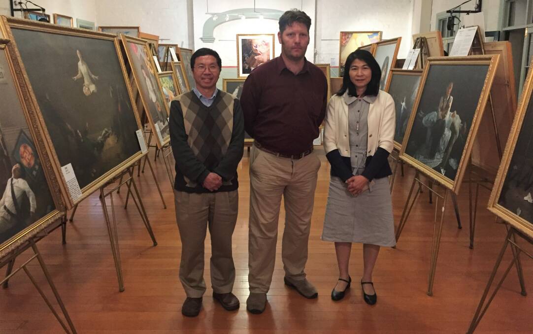 Spreading the message: Falun Dafa practitioner and exhibition curator Daniel Clark (centre) with fellow coordinators Songfa Liu (left) and Xuan Tieu (right) say the exhibition aims to bring awareness of human-rights abuse of Falun Dafa practitioners in China. Photo: Toby Vue