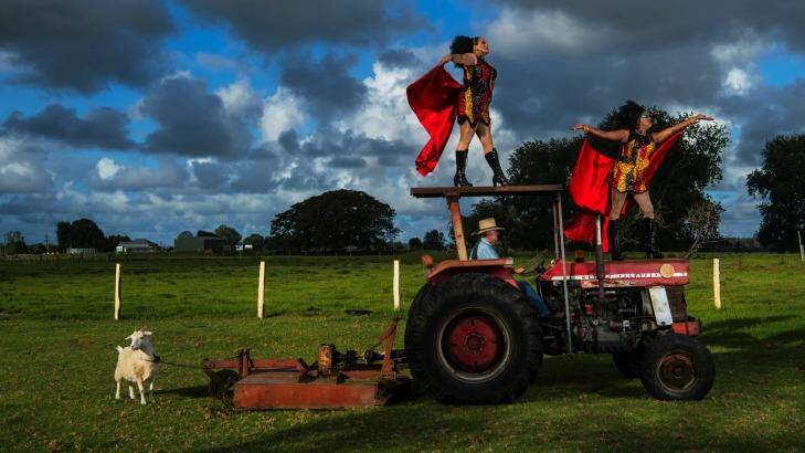 Dreamtime Divas Dallas ‘‘Nova Gina’’ Webster, right, and Tim "Lasey Dunaman" Towns strut their stuff on Allan Prior's tractor outside Kempsey. The goat, Nick, looks away. Photo: Nic Walker