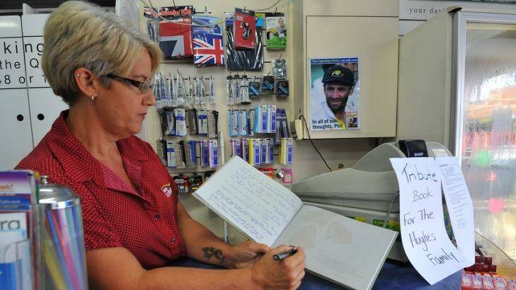Macksville newsagent Tracey Spear with a tribute book where locals can leave a message for the Hughes family. Photo: Bruce Thomas