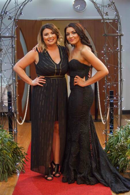 Kate Wylie and Liana Wylie swapped their Girlpies jerseys for formal gowns for the Magpies Black and White Ball at the Soldier's Club on Saturday night: Photo: Heidi Grange Photography.