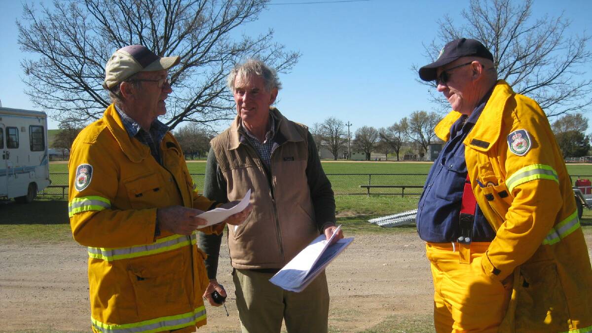 Local RFS members Doug Darbyshire and Steve Kearns get a briefing from Kangaroo March organiser David Williamson. 
