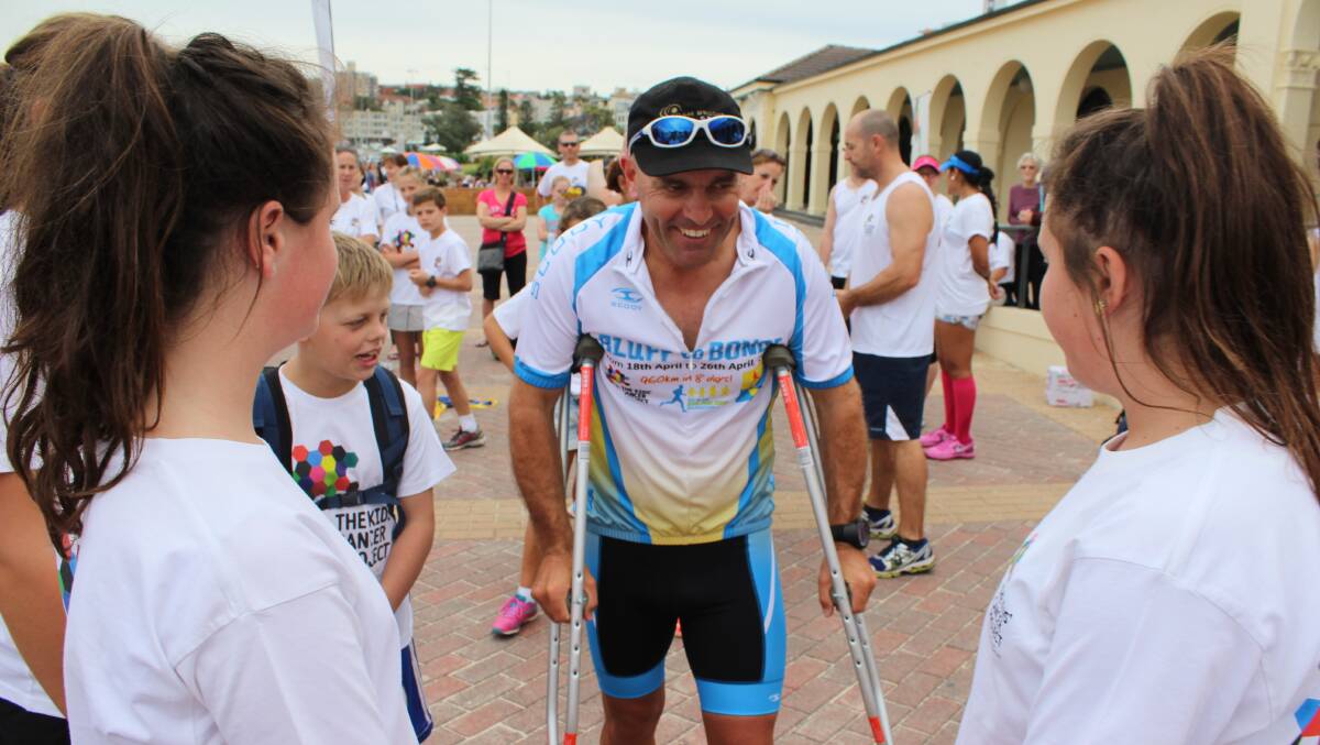 Tim Blair tries out his new crutches after finishing the bluff to bondi