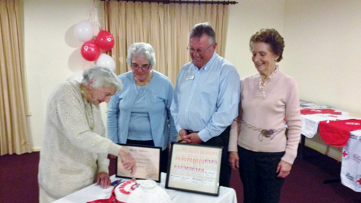 Cutting the 100th Anniversary cake last year is Binalong Red Cross patron Isobel McDonald, watched by vice-president Pat Allen, regional manager Murray Riverina John Pocius and vice-president Gwen Sykes.
