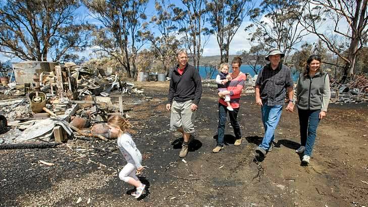 Tammy and Tim Holmes and family at their property near Dunalley on Friday. The family had to shelter underneath a small jetty with their grandchildren to escape from the recent bushfire on Tasmania's east coast.