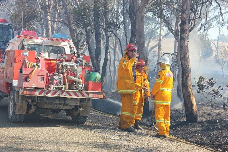 Gunning RFS volunteer fire fighters take a breather as the Gundaroo fire on Monday was finally contained. Photo: Chris Gordon, Goulburn Post.