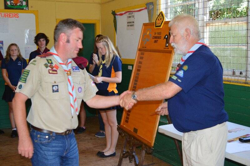 Adam Farquharson is presented with a plaque with his name on it to go on the Queens Scout honour role for the 1st Yass Combined Unit.