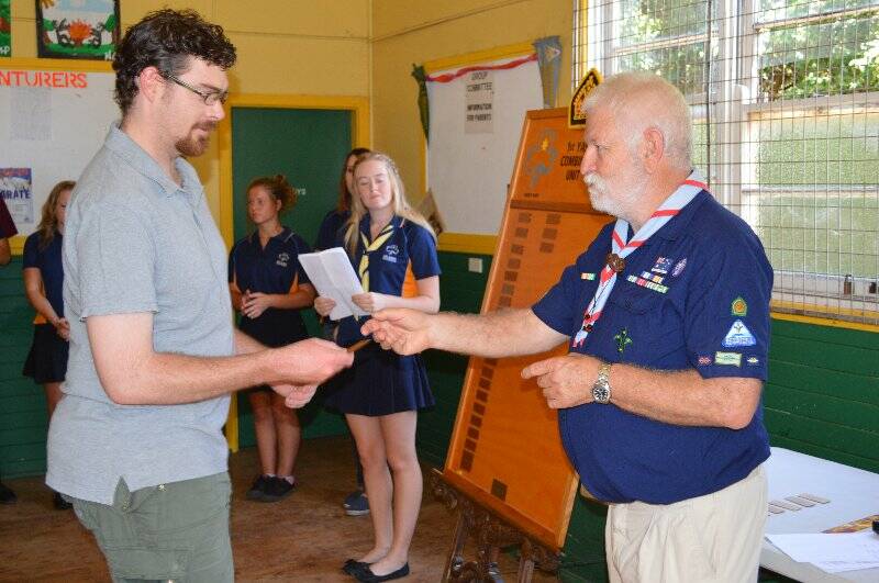 Daniel Pearsall is presented with a plaque with his name on it to go on the Queens Scout honour role for the 1st Yass Combined Unit.