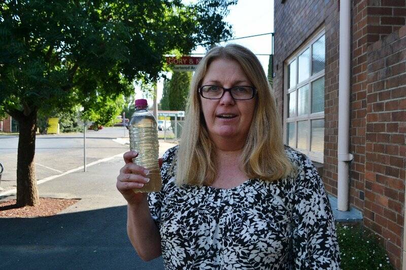 Gayle Buttrose with a bottle of the "icky" water that came out of her kitchen tap recently. Photo: Karan Gabriel.