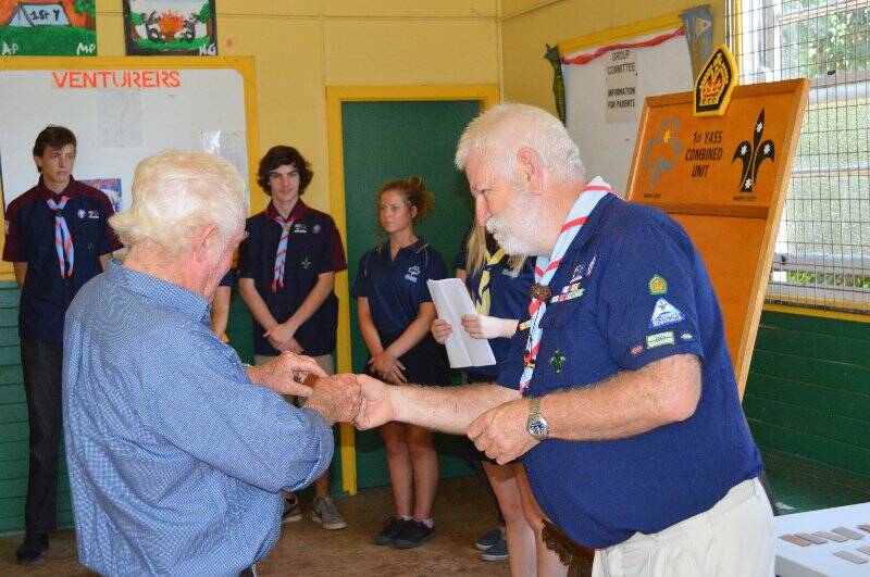 Vince NcNally is presented with a plaque with his name on it to go on the Queens Scout honour role for the 1st Yass Combined Unit.