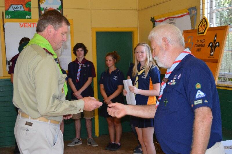 Wayne Puckett is presented with a plaque with his name on it to go on the Queens Scout honour role for the 1st Yass Combined Unit.