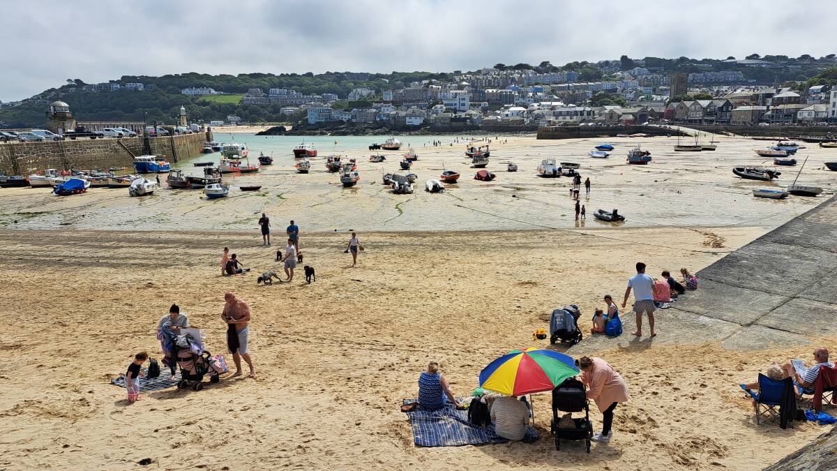 The tide is six metres high in St Ives, Cornwall, and when it goes out, the beach-goers descend. Picture: Sarah Falson The tide is six metres high in St Ives, Cornwall, and when it goes out, the beach-goers descend. Picture: Sarah Falson