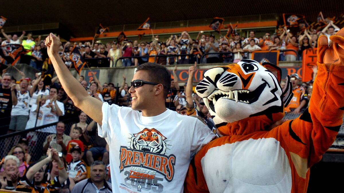 OF TIGERS' GLORY: Captain at the time,Scott Prince is escorted by the Wests Tigers mascot at Leichhardt Oval in October, 2005. Picture: AAP