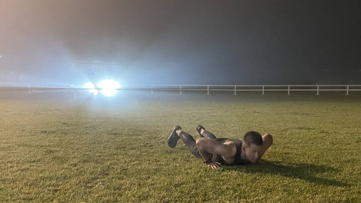 HUGE EFFORT: Todd Cremer starts another burpee out in the middle of the Kangaroo Valley Showground by himself during his marathon 10-hour effort. Photo: Supplied