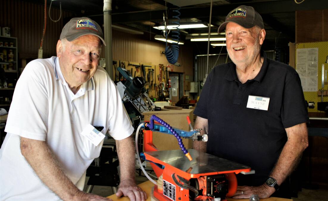 Yass Valley Men's Shed president Bob Nash and Wayne Stuart check out a new scroll saw the club secured in 2019. Mr Stuart has been awarded an OAM for his involvement over nearly 15 years. 