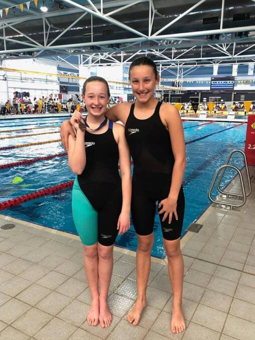 Personal bests: Lara McLelland (left) and Tahlia Wullaert are all smiles after their excellent performances at the AIS on Sunday. Photo: Yass Swimming Club/Facebook.