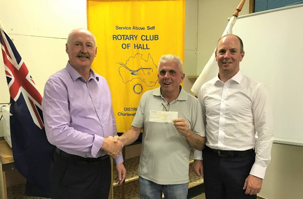 SUPPORT: Paul Tyrell, Hall Rotary President, hands a $5000 cheque to Peter Clark (centre), president of the brigade, and former president Kane Fillingham. Photo: Supplied