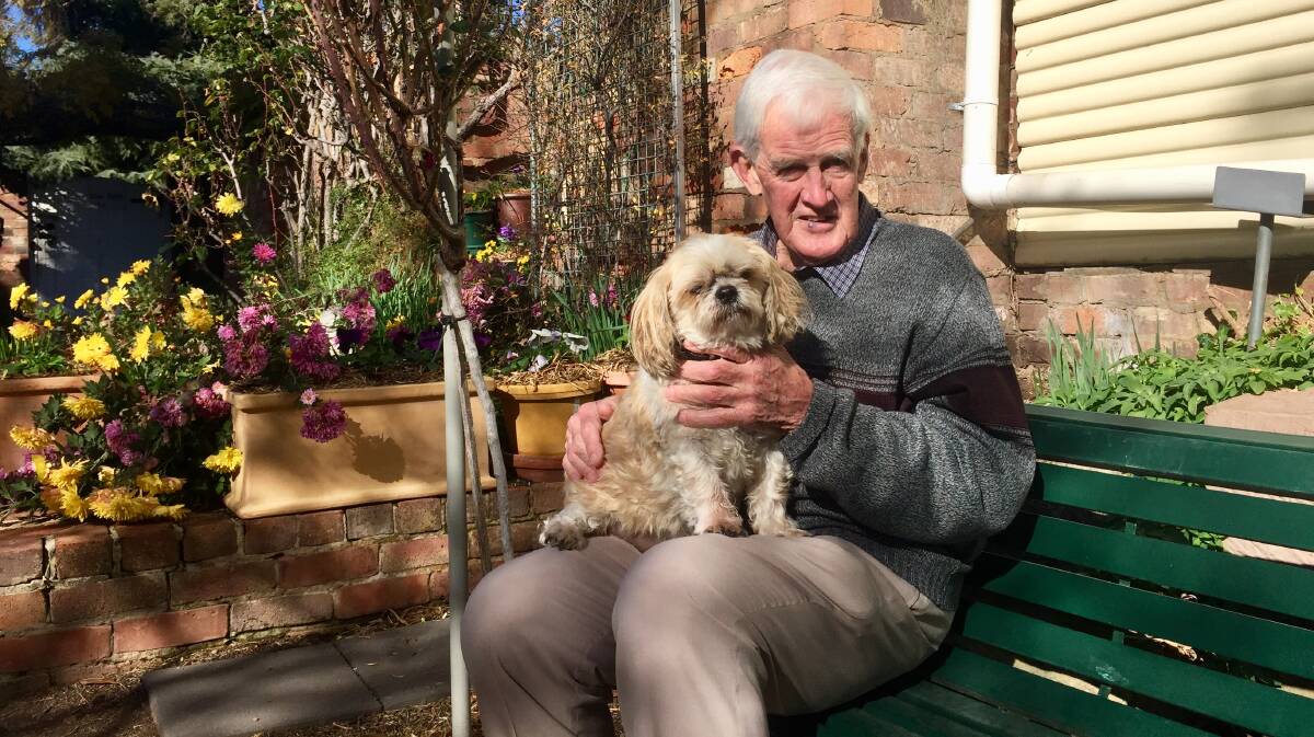 STRENGTH REGAINED: Brian O'Connor, who recently recovered from sepsis and breast-cancer surgery, with his pet dog, Jammy, at their home garden in Yass. Photo: Toby Vue.