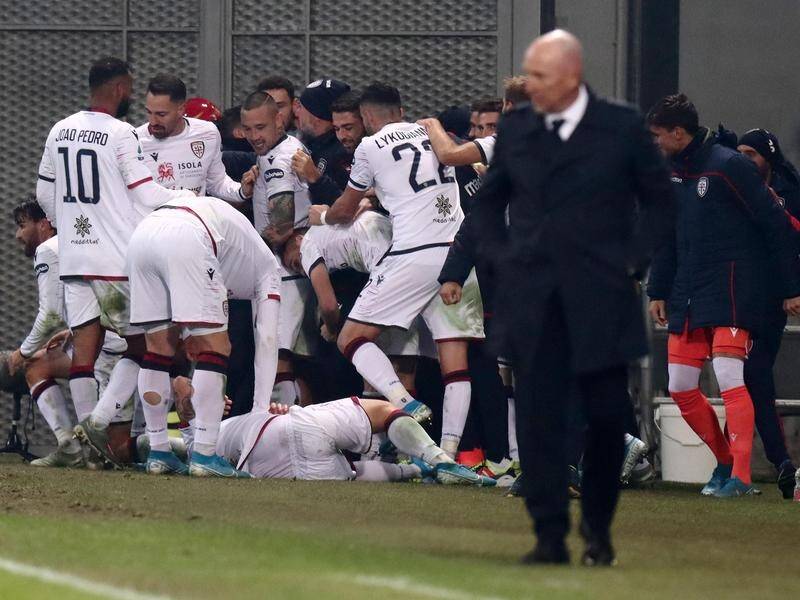 Cagliari's players mob teammate Daniele Ragatzu (bottom) after he salvaged a 2-2 draw at Sassuolo.