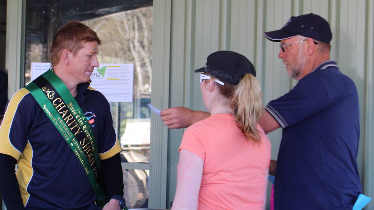 Mick Bryan from Nowra is presented with a Sash after winning the Yass Clay Target Club Annual Charity Shoot recently. Pictured Nicole Crisp (representing the Crisp family who donated the Sash) and club president Paul Watchorn.