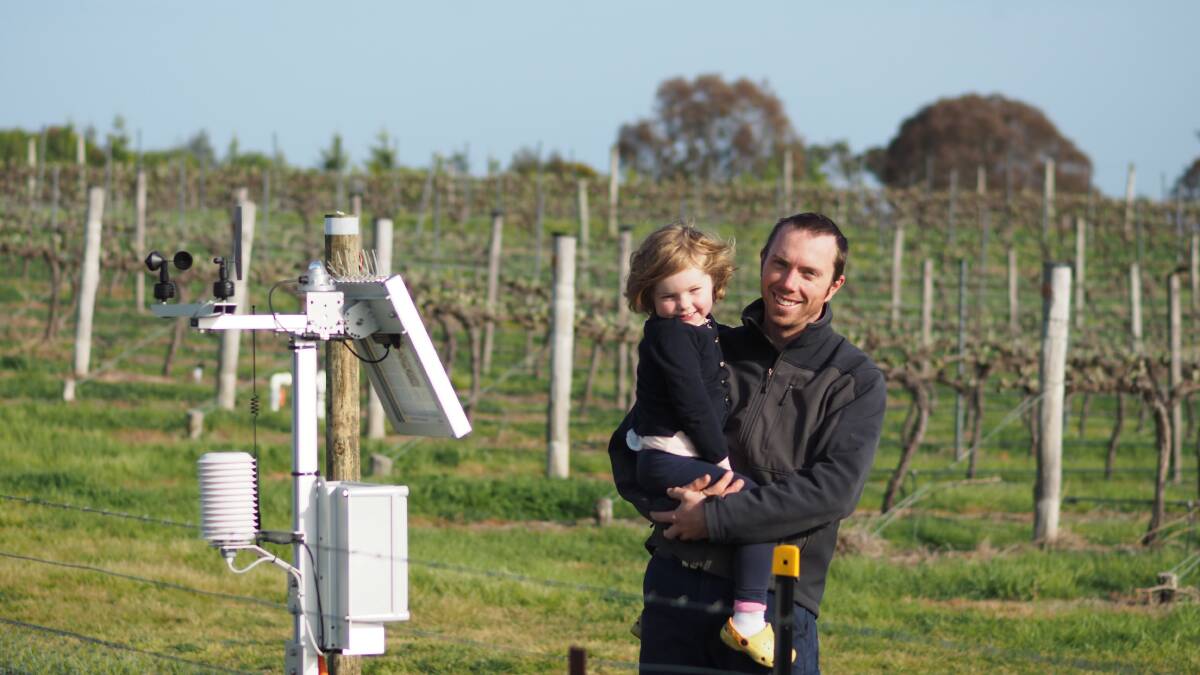 Manager of Four Winds Vineyard John Collingwood with his daughter Eloise, next to the new weather station at their Vineyard. Photo: Sarah Collingwood. 
