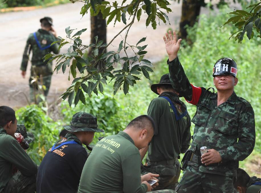 A Thai military policeman holds up his hand indicating 5 the number of people being rescued today from Tham Luang cave.  Picture: Kate Geraghty
