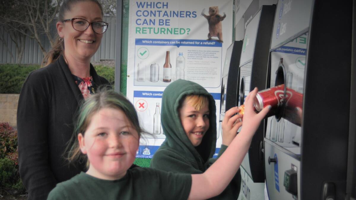 DONATE: Berinba Public P&C president Jean Pearson, Bridgette Pearson, 8, and Eric Pearson, 10, return cans at the Yass Woolworths collection point. Photo: Hannah Sparks
