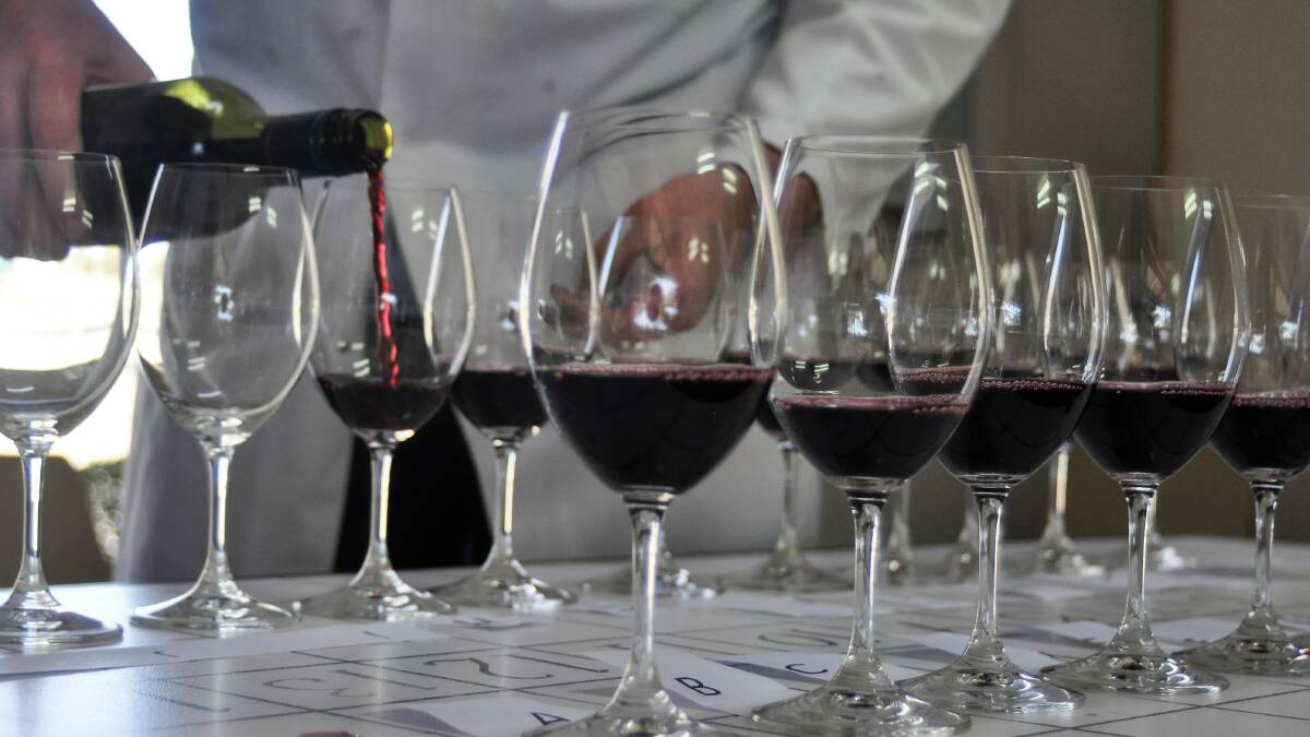 A steward pours shiraz wines for judges at the Australian Cool Climate Wine Show. Photo: Hannah Sparks