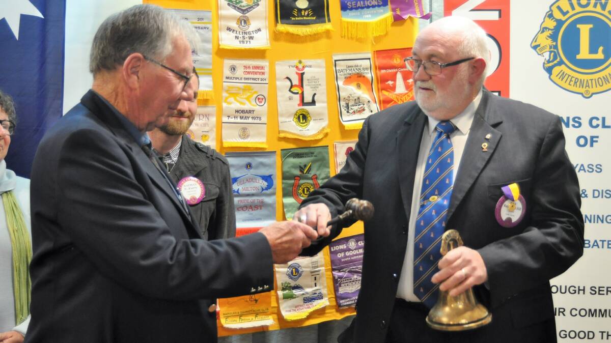 Changeover: Lions Club of Yass outgoing president Stan Luff hands over to incoming president Ray Hill. Photo: Hannah Sparks