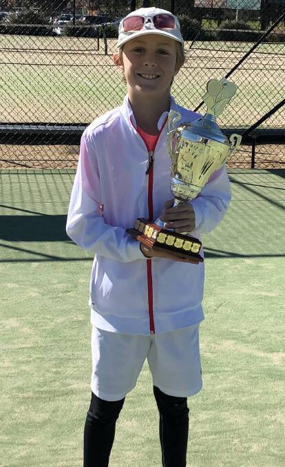 Winner: Nine-year-old Angus Kelly holding his NSW South West Champion of Champions tennis tournament. Photo: Maree Kelly. 