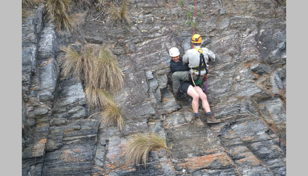SOFT LANDING: Sydney visitor and camper at Mystery Bay Matthew Hibbert made it to the bottom of the cliff assisted by Narooma VRA vertical rescue team member Steve Urquhart. 