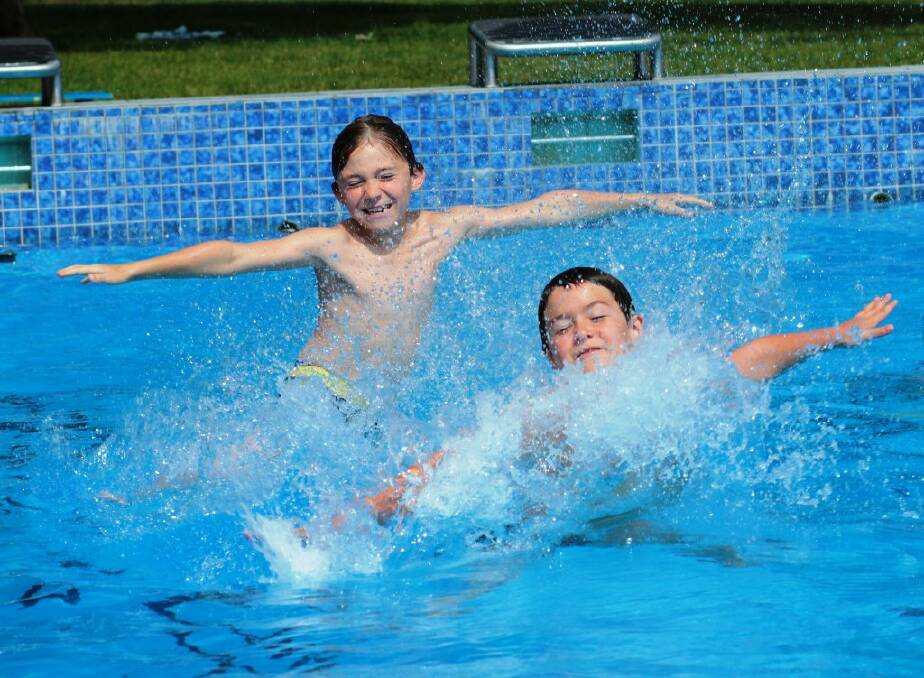 Riley Wilson, 8, and Darcey Bush, 8, plunge into summer at Yass pool.