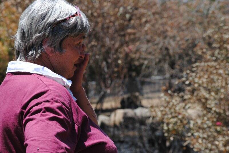 Hansie Armour wipes ash, not tears, from her face as she assesses the damage on her property on Childowla Road. Photo: Katharyn Brine.