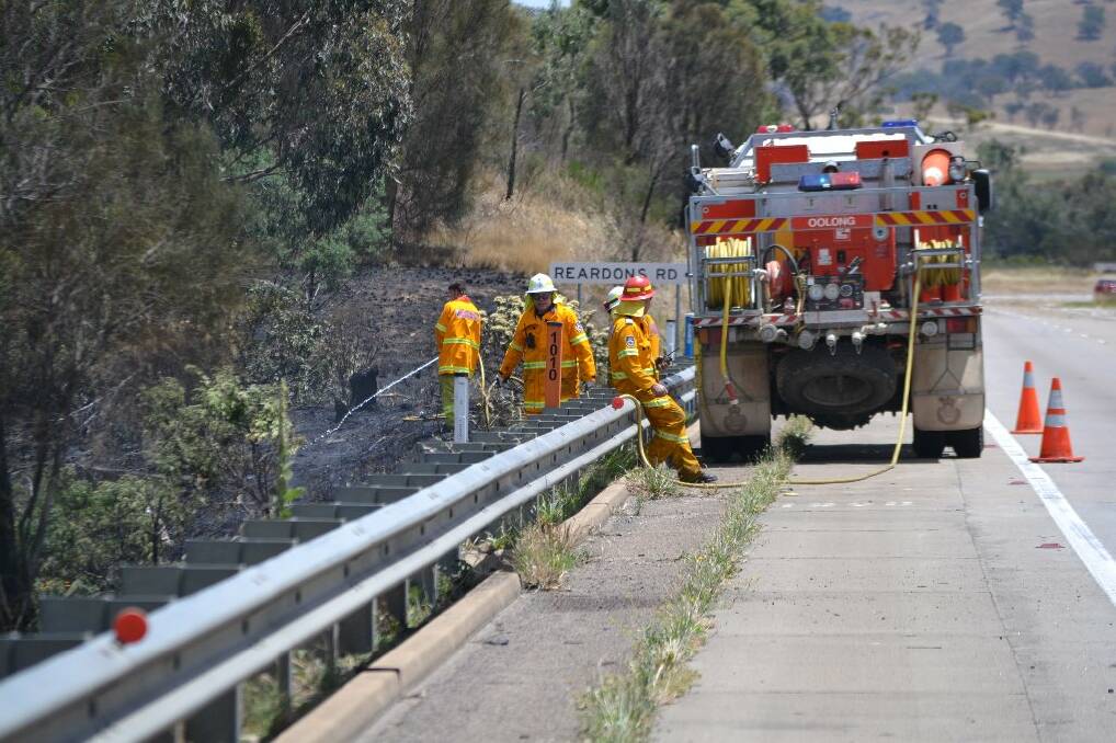 olunteer fire fighters mop up a fire on the Hume Highway at the base of the Mundoonen Range. 