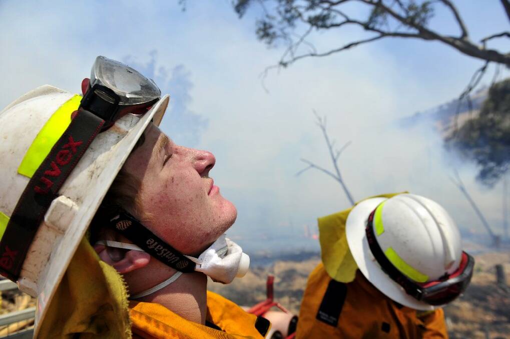 Bowning fire fighter Lachlan O'Mara, 16, looks to the heavens at the fire front on Wednesday. Photo: Photo: Jay Cronan.